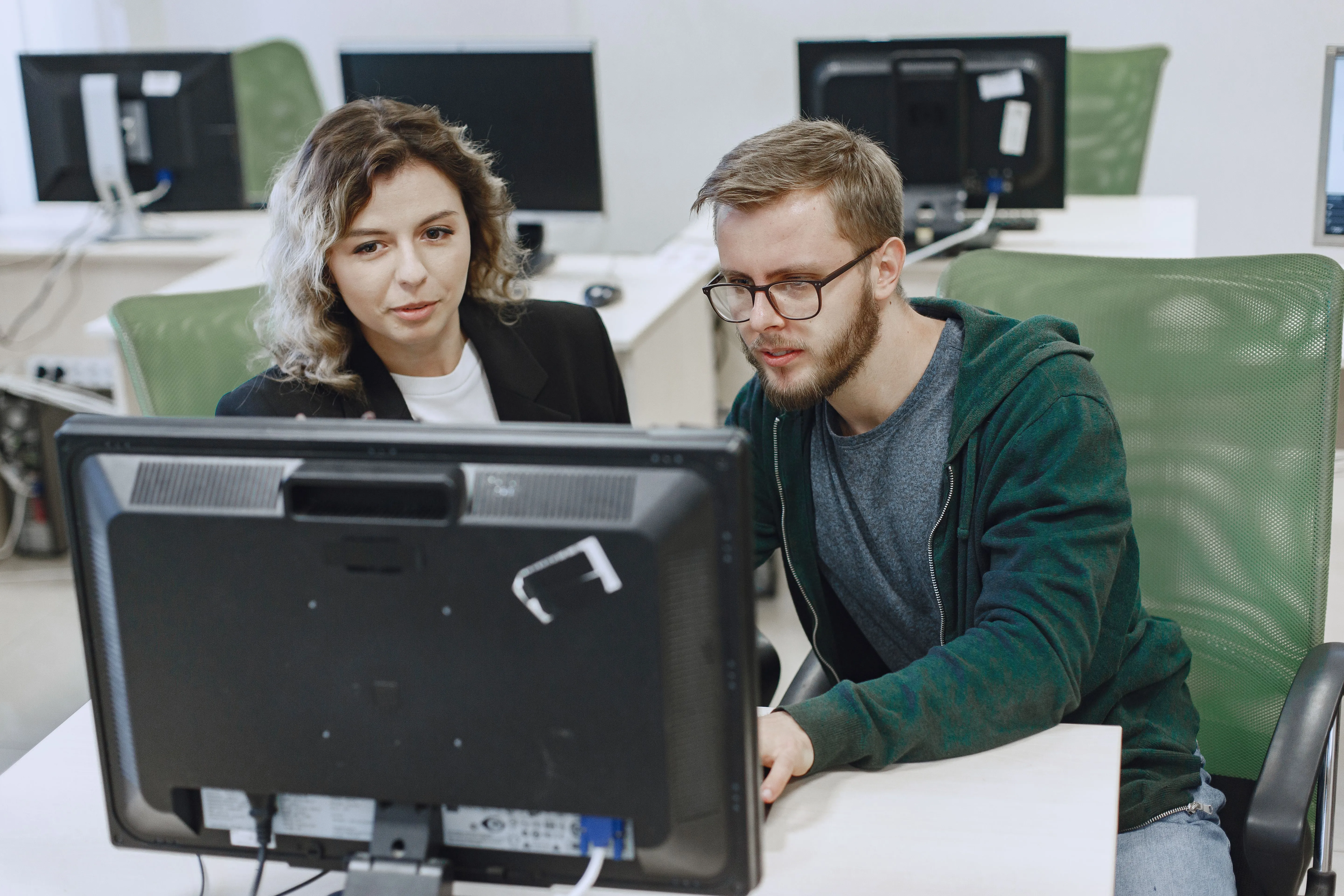 Zwei Personen arbeiten gemeinsam an einem Computer